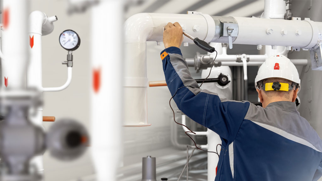 Responsable maintenance vérifie installation propane en citerne dans atelier